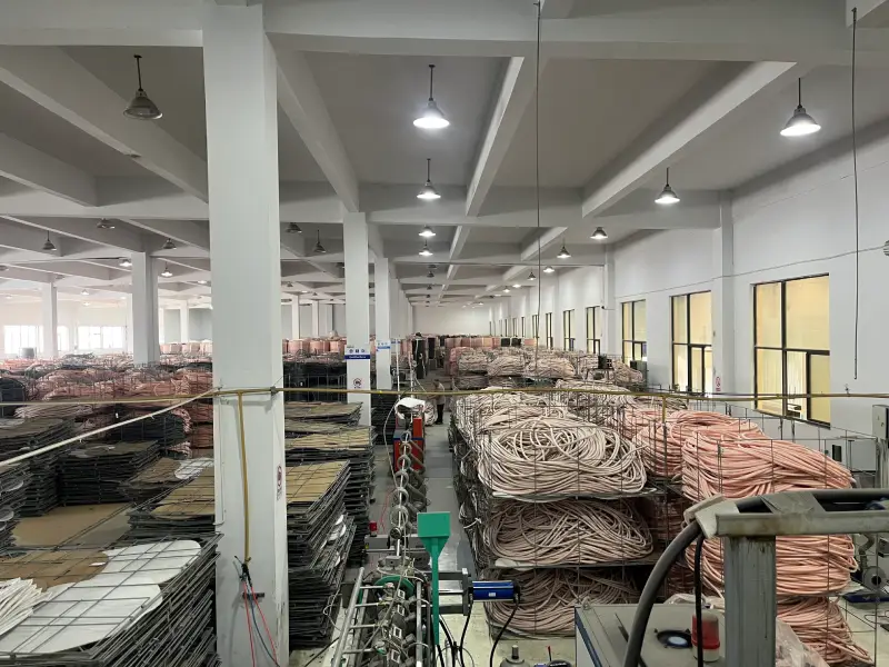 Overview of an insulated copper tube factory workshop with production lines and product storage cages