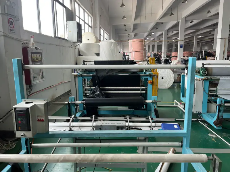 Laminating machine processing black insulation film in the workshop of an insulated copper tube supplier