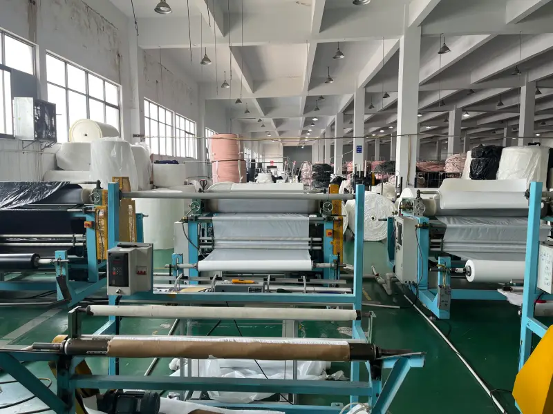 Laminating machine processing white insulation film at a copper tube insulation material factory